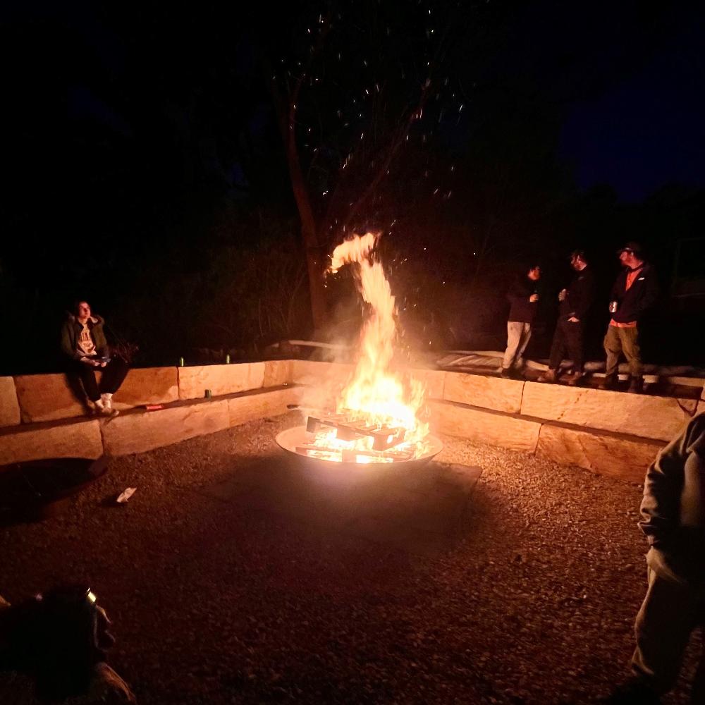 The Crucible Fire Pit with a fire burning at night in large backyard - Hot Fire Pits Australia