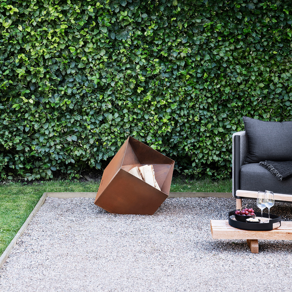 Firecube Fire Pit by Eva Solo ready to burn a fire in an outdoors setting