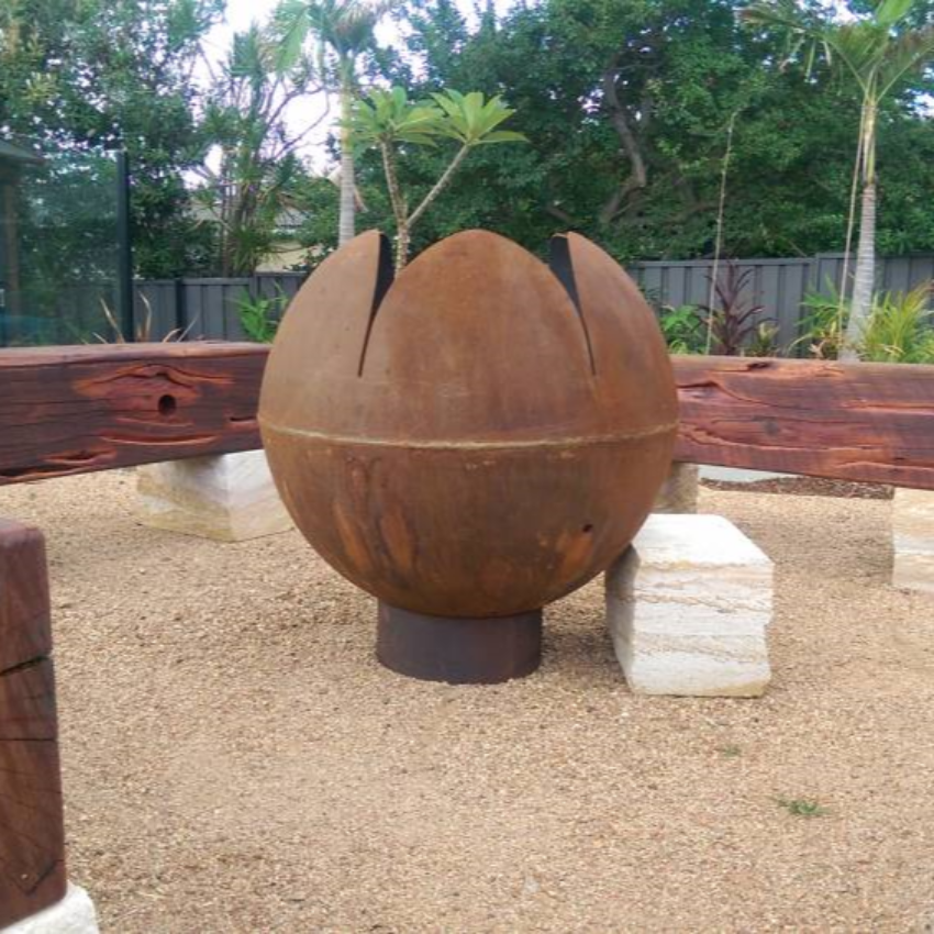 The Lotus Fire Pit in a pretty garden setting