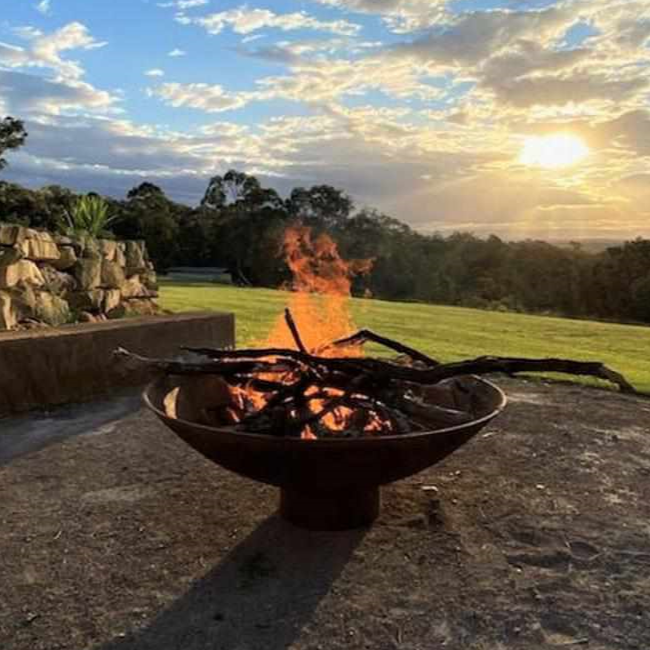 The Cauldron Fire Pit 1500mm burning a fire with sunset in background