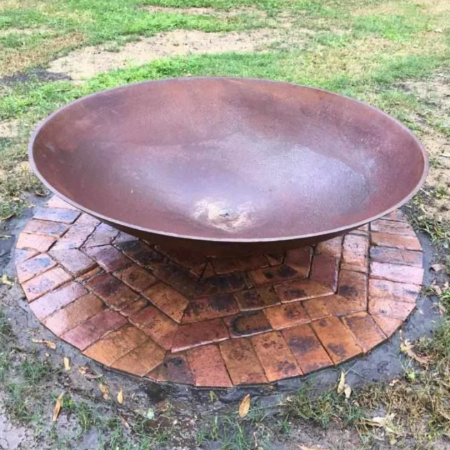 The Cauldron Fire Pit 1500mm set up on pavers in lawn area