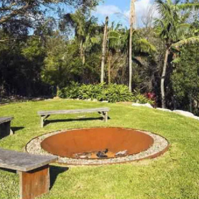 The Cauldron Fire Pit 1500mm sunk into the ground with wooden benches around it