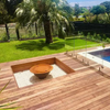 The Teppanyaki Fire Pit and lid in backyard beside a pool