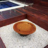 The Teppanyaki Fire Pit with lid on in backyard beside a pool