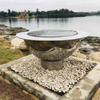 The Teppanyaki Stainless Steel Fire Pit and grill beside a lake