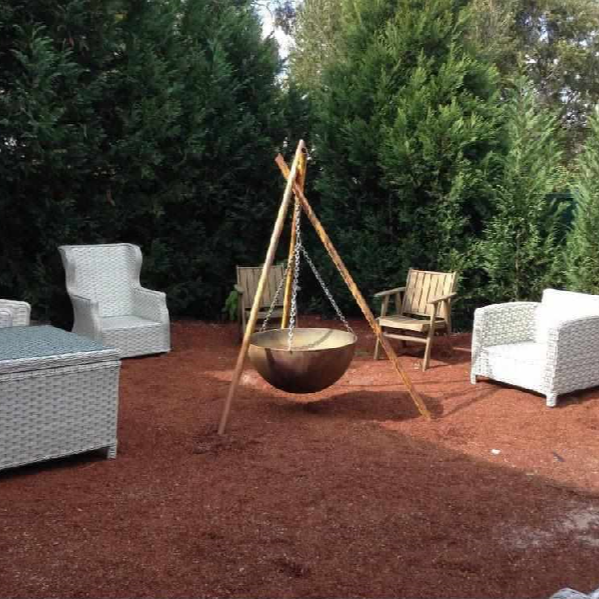 The Tripod Fire Pit in a garden setting