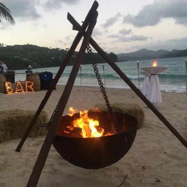 The Tripod Fire Pit on a beach at a party setting