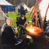 The Tripod Fire Pit at a campsite with people gathering