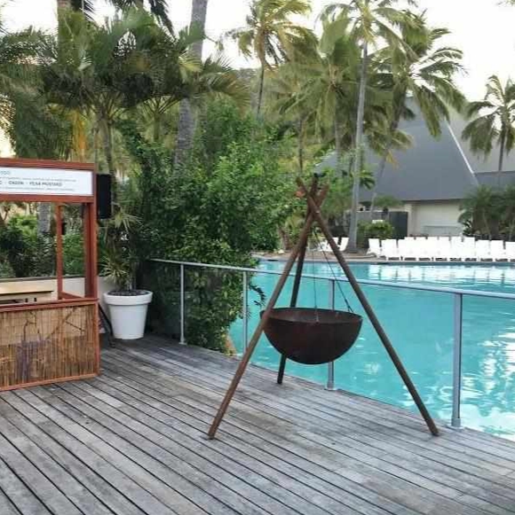 The Tripod Fire Pit on a deck at a pool side